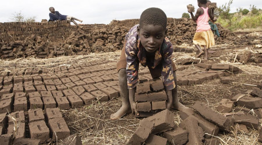 A boy lifts dry raw bricks and takes them to a kiln where they will be burned during work to earn money at Jumpha Village, Traditional Authority Chitukula in Lilongwe, central Malawi, June 7, 2019. - Child labour is still a problem in Malawi due to two factors of poverty and culture. June 12 marks International Day against Child Labour. The International Labour Organization (ILO) launched the World Day Against Child Labour in 2002 to focus attention on the global extent of child labour and the action and efforts needed to eliminate it. Each year on June 12 , the World Day brings together governments, employers and workers organizations, civil society, as well as millions of people from around the world to highlight the plight of child labourers and what can be done to help them. (Photo by AMOS GUMULIRA / AFP)